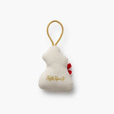 Cream-colored bear ornament with red bow and gold rope loop by Rifle Paper Co.