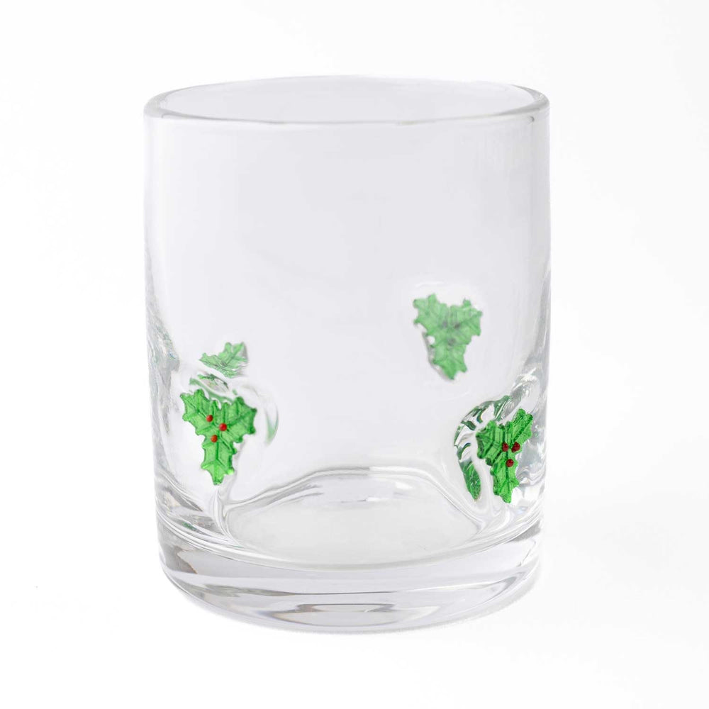 Clear drinking glass with green holly leaf and red berry design on white background