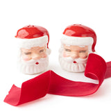 Red and white ceramic Santa Claus salt and pepper shaker set with red ribbon bow on white background