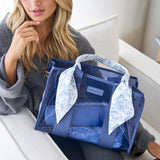 Woman holding blue and white floral patterned Case-Mate jelly tote bag, seated indoors
