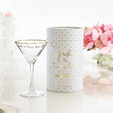 Gold foil martini glass with 'Just a Tini Bit Older' text next to polka dot packaging and pink flowers