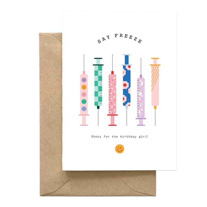 Greeting card with colorful syringe illustrations and a brown envelope on a white background