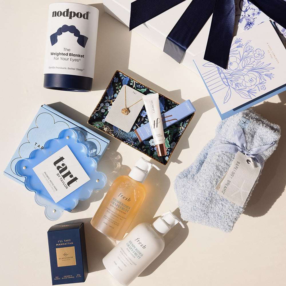 Collection of beauty and wellness products on a light beige background, ready to pack into a gift box with a blue ribbon.