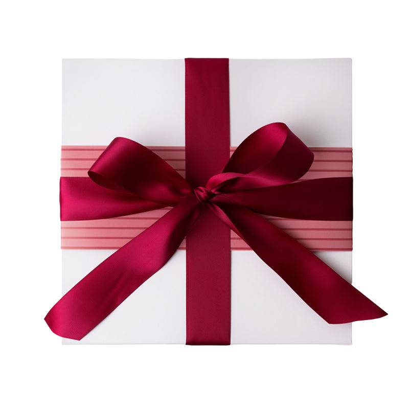 gift box wrapped with a pink and red striped sleeve and a red ribbon
