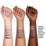 Three hands with makeup swatches on a white background