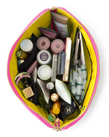 KUSSHI | Vacationer Makeup Bag — Flamingo Pink/Sunshine Yellow, A pink and yellow makeup bag shown from above, filled with various cosmetics and skincare items on a white background.